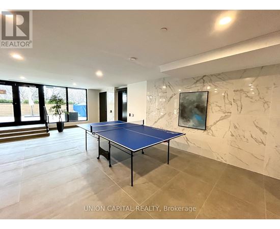A blue table tennis table in a spacious room with marble walls.
