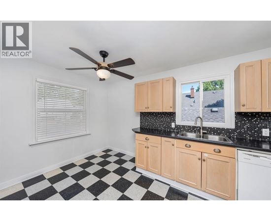 A black and white checkered floor in a kitchen with wooden cabinets.