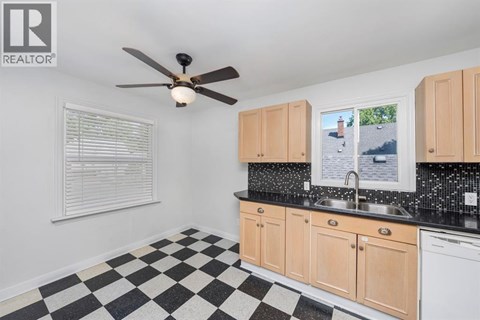 A black and white checkered floor in a kitchen with wooden cabinets.