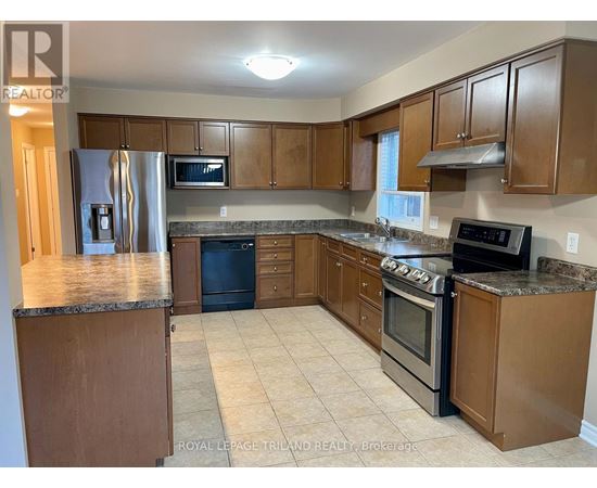 A kitchen with wooden cabinets and a granite countertop.