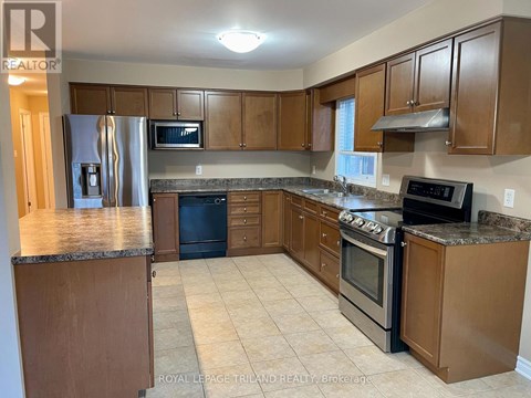 A kitchen with wooden cabinets and a granite countertop.