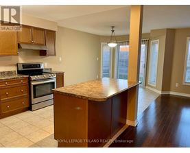 A kitchen with a granite countertop and wooden cabinets.