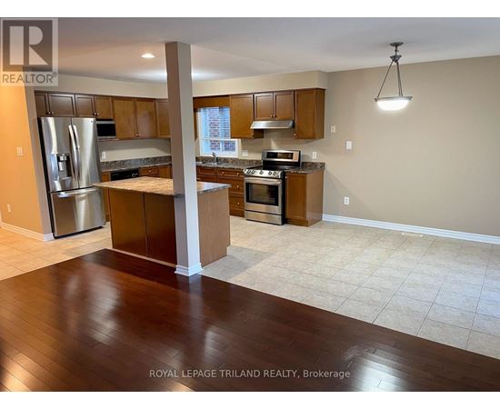 A kitchen with a refrigerator, oven, and microwave.