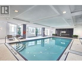 A large indoor swimming pool with a tiled edge and a small pool area to the left.