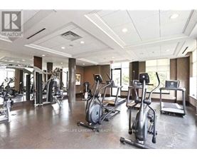 A gym with a variety of exercise equipment including treadmills, elliptical machines, and weight machines.