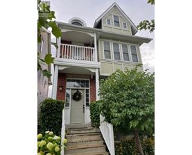 A house with a grey front door and a wreath on it.