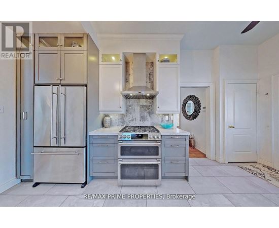 A kitchen with a stainless steel refrigerator and oven.