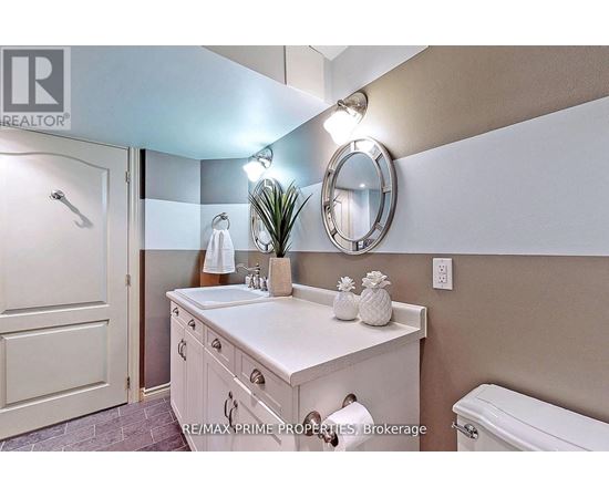 A bathroom with a white sink and a round mirror.