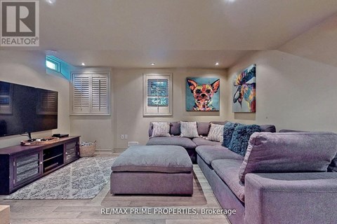 A living room with a grey couch and a television.