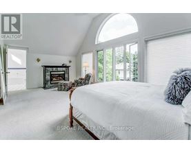 A bedroom with a large bed and a fireplace.