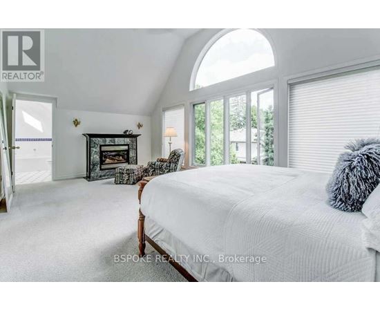 A bedroom with a large bed and a fireplace.