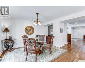 A dining room with a wooden table and chairs.