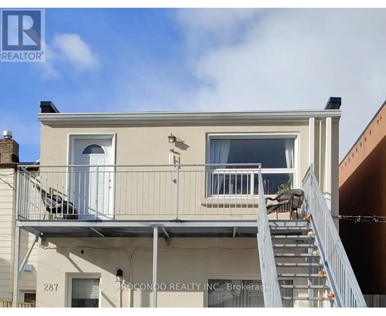 A two-story building with a balcony and a staircase leading to the second floor.