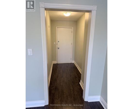 A hallway with a white door and a light on the ceiling.