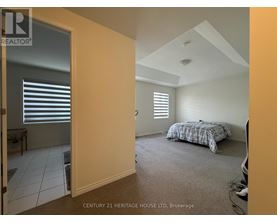 A bedroom with a bed and a window with blinds.