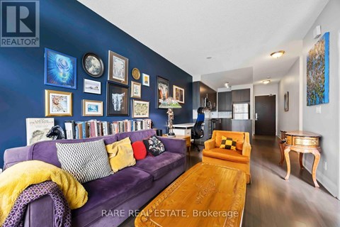 A living room with a purple couch and a wooden coffee table.
