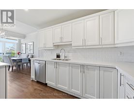 A kitchen with white cabinets and a dining table.