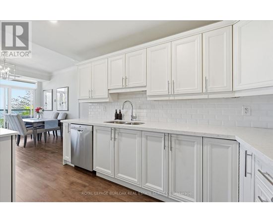 A kitchen with white cabinets and a dining table.