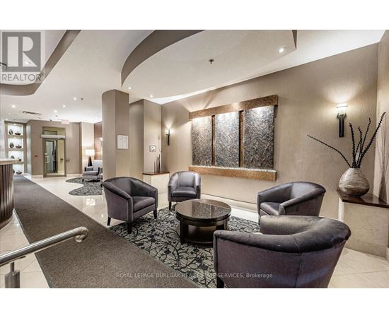 A living room with a glass table surrounded by leather chairs.