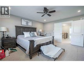 A bedroom with a large bed and a ceiling fan.