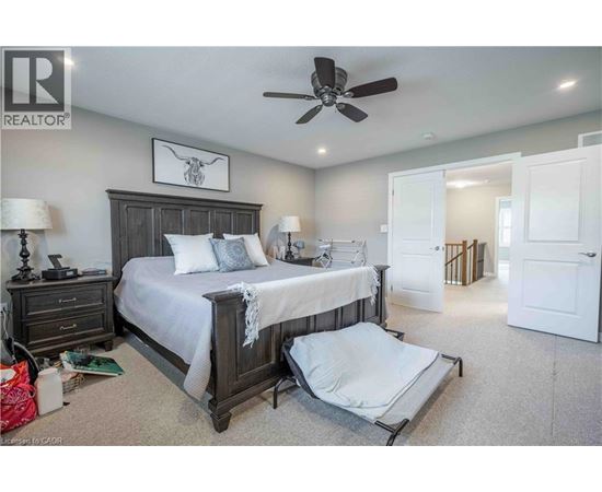A bedroom with a large bed and a ceiling fan.
