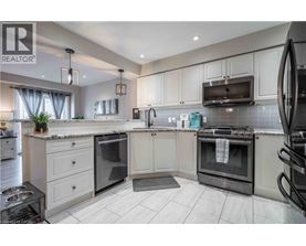 A modern kitchen with white cabinets and black appliances.