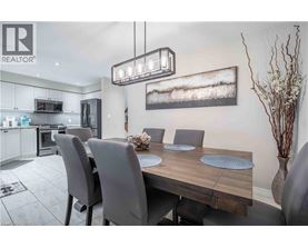 A modern dining room with a wooden table and grey chairs.