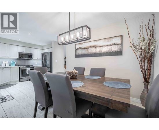 A modern dining room with a wooden table and grey chairs.