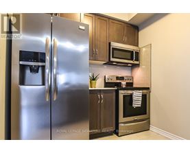 A modern kitchen with a stainless steel refrigerator and oven.