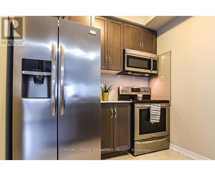 A modern kitchen with a stainless steel refrigerator and oven.