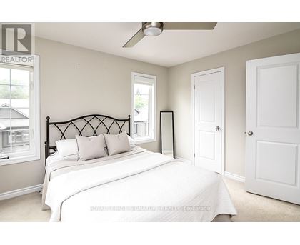 A bedroom with a large bed and a ceiling fan.