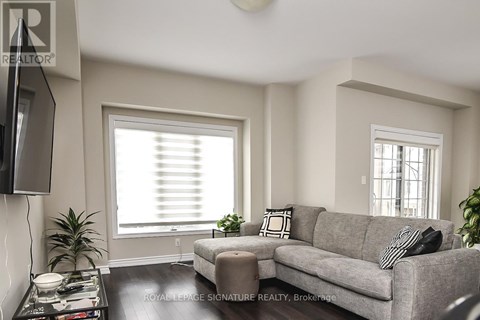 A living room with a grey couch, a black and white pillow, a black television and a black coffee table.