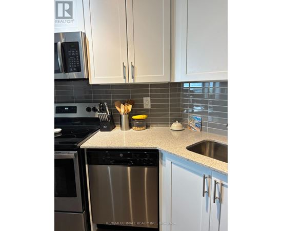 A kitchen with a stainless steel dishwasher and white cabinets.