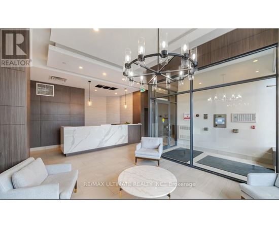 A modern office lobby with a white reception desk and a glass wall.