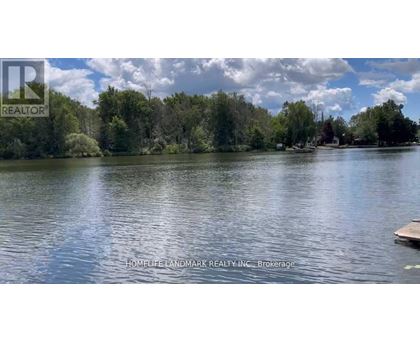 A serene lake surrounded by trees under a clear sky.