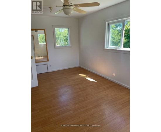 A room with wooden floors and a ceiling fan.