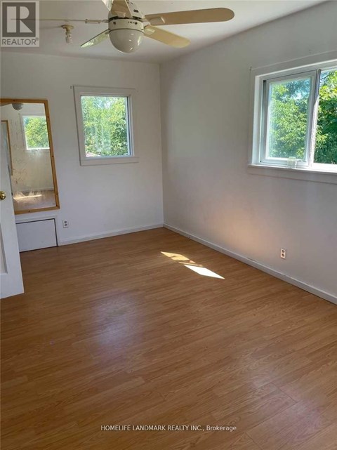 A room with wooden floors and a ceiling fan.