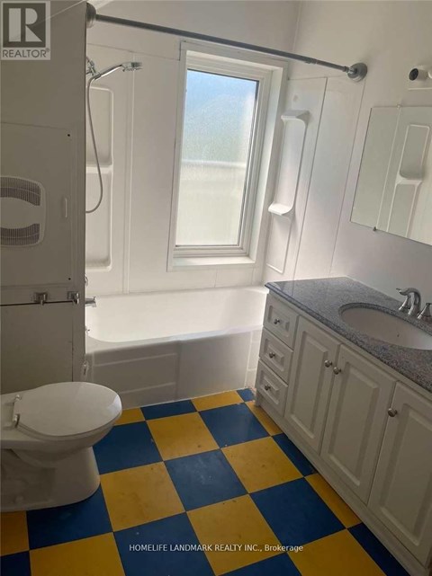 A bathroom with a toilet, sink, and bathtub.