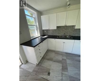 A kitchen with white cabinets and a black countertop.