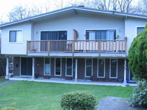 A house with a balcony and a small garden.