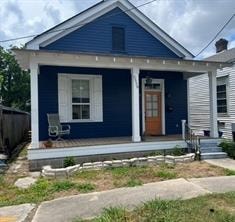 A small blue house with a porch and a brown door.