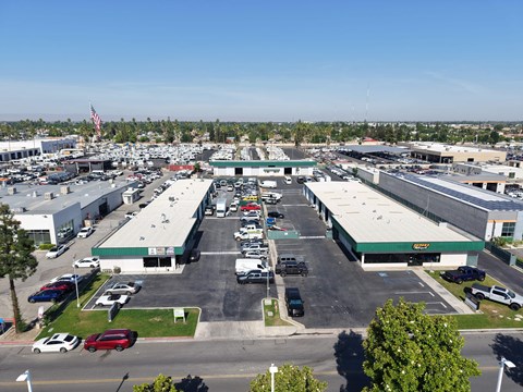 A large parking lot with several cars and buildings in the background.