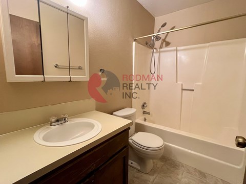 A bathroom with a sink, toilet, and bathtub.