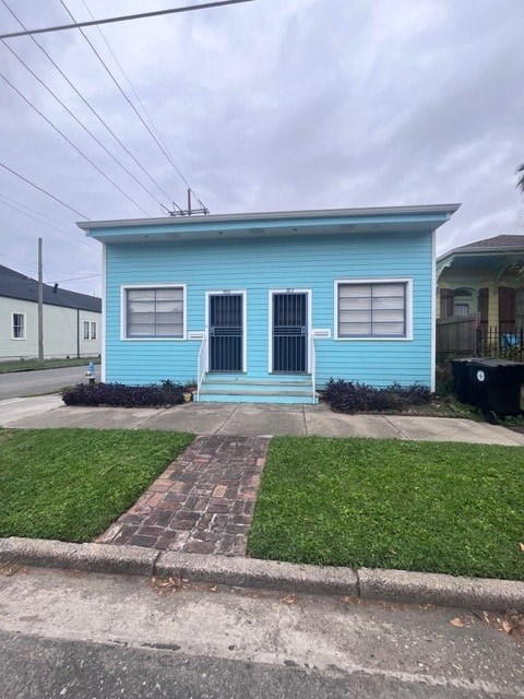 A blue house with a black door and windows.