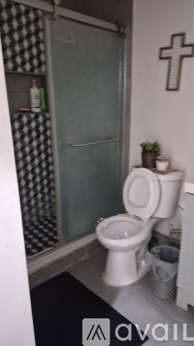 A white toilet in a small bathroom with a glass shower door.