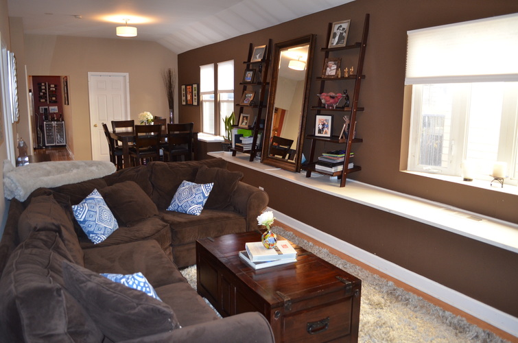 A brown couch with blue pillows sits in a living room.