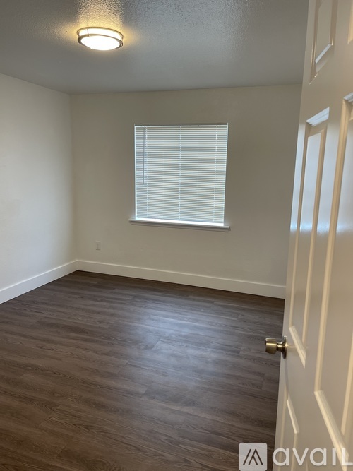 A room with wooden flooring and a white door.