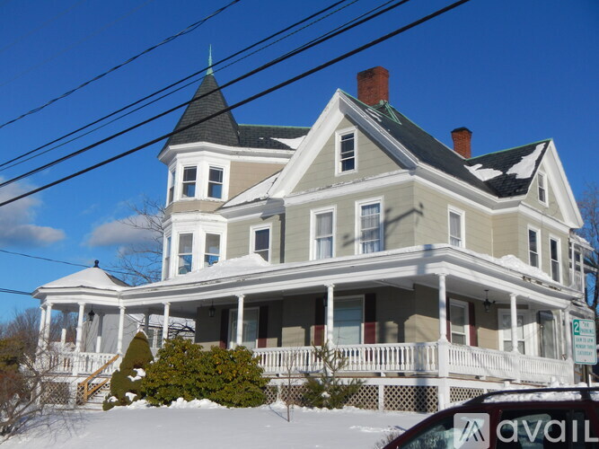 A house with a white fence and a car parked in front.