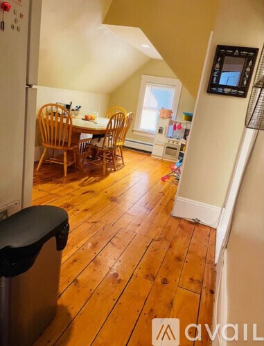 A kitchen with wooden floors and a dining table with chairs.