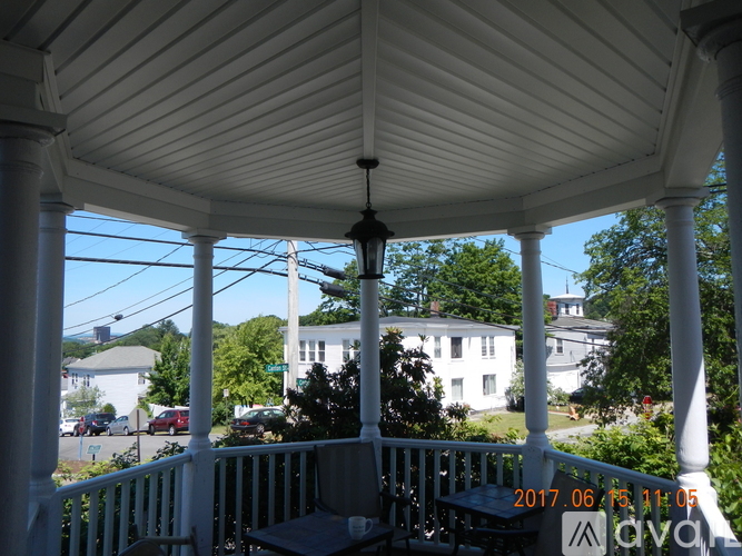 A white gazebo with a wooden roof and four white columns.